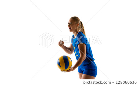 Female volleyball player holding ball and cheering with joy 129060636