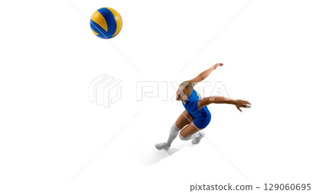 Female volleyball player in blue outfit jumping to hit ball Female volleyball player in blue outfit jumping to hit ball 129060695
