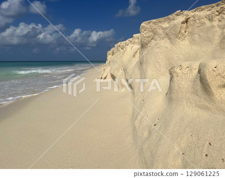 Golden sand shaped by waves on a tropical Aruba beach 129061225