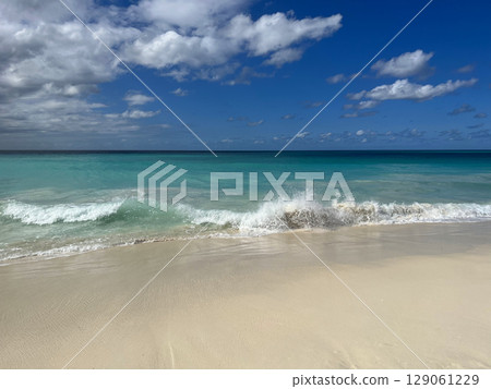 A pristine tropical Aruba beach with powdery white sand and turquoise water under a bright blue sky. Caribbean travel concept 129061229