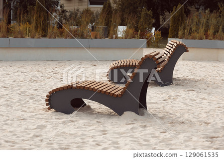Two wooden sun loungers without people on beach 129061535