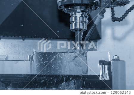 The CNC milling machine rough cutting the mold parts with oil coolant method in the blue tone scene. 129062143