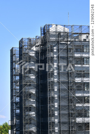 Yokohama cityscape in Japan: Summer sky spreads out... View of scaffolding and protective netting for repairs and inspections of apartment buildings Yokohama cityscape in Japan: Summer sky spreads out... View of scaffolding and protective netting for repairs and inspections of apartment buildings 129062148