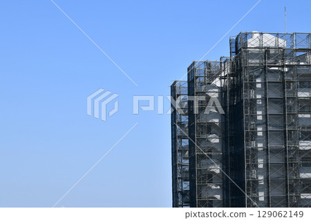 Yokohama cityscape in Japan: Summer sky spreads out... View of scaffolding and protective netting for repairs and inspections of apartment buildings Yokohama cityscape in Japan: Summer sky spreads out... View of scaffolding and protective netting for repairs and inspections of apartment buildings 129062149