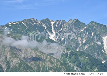 Summer sky and remaining snow on the Hakuba mountain range, Mt. Karamatsu and Mt. Fukiya / Nagano Prefecture 129062393