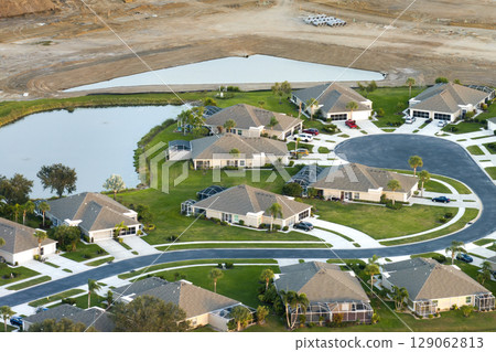 Premium housing development in the USA. Expensive houses between green palm trees in southwest Florida Premium housing development in the USA. Expensive houses between green palm trees in southwest Florida 129062813