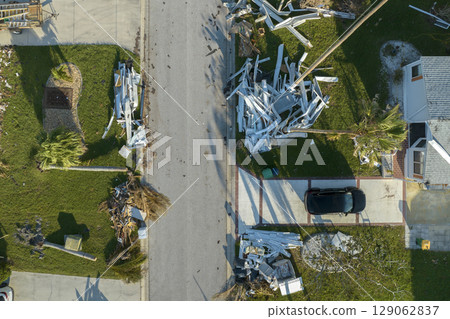 Piles of rubbish on street side from severely damaged houses after hurricane Ian in Florida mobile home residential area. Consequences of natural disaster 129062837