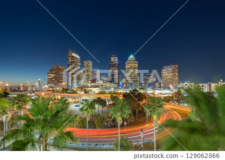 Night urban landscape of downtown district of Tampa in Florida, USA. American city skyline with brightly illuminated high commercial buildings and high speed highway road 129062866