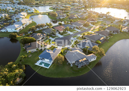 Low-density private homes at sunset. Rural street cul-de-sac dead end in residential suburbs with upscale suburban houses outside of Sarasota, Florida Low-density private homes at sunset. Rural street cul-de-sac dead end in residential suburbs with upscale suburban houses outside of Sarasota, Florida 129062923