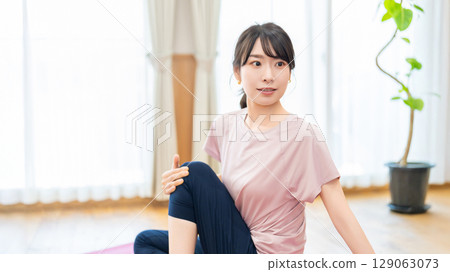 Woman stretching in the living room at home 129063073