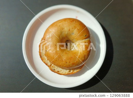 Freshly Baked Bagel Served on a White Plate 129063888