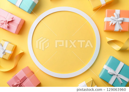 A round, blank cream-colored frame is centered on a vibrant yellow background, surrounded by various colorful gift boxes and party decorations. A round, blank cream-colored frame is centered on a vibrant yellow background, surrounded by various colorful gift boxes and party decorations. 129063960
