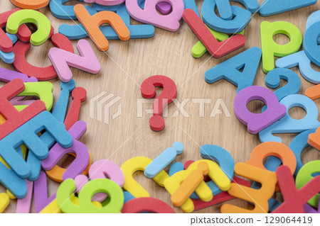 Background of question marks and letters placed on wood grain Background of question marks and letters placed on wood grain 129064419