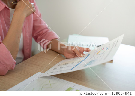 Work from Home. Woman reviewing financial report with focus. Work from Home. Woman reviewing financial report with focus. 129064941