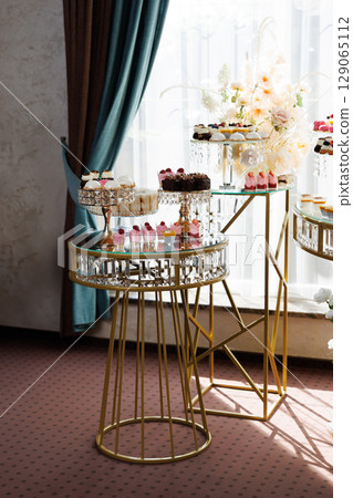 Delicious desserts decorating elegant candy bar table for wedding reception Delicious desserts decorating elegant candy bar table for wedding reception 129065112