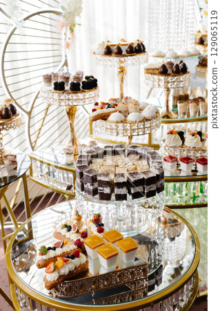 Delicious macarons and pastries decorating a luxurious candy bar buffet Delicious macarons and pastries decorating a luxurious candy bar buffet 129065119