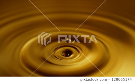 Freeze Motion of Splashing Whiskey or Cider Drop. Super Macro Shot, Extreme Close-up. 129065174