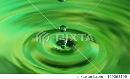Green Water drop falling, macro splash. Natural background. 129065196