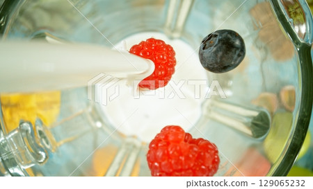 Mixing pieces of fruits in blender, top view. Mixing pieces of fruits in blender, top view. 129065232