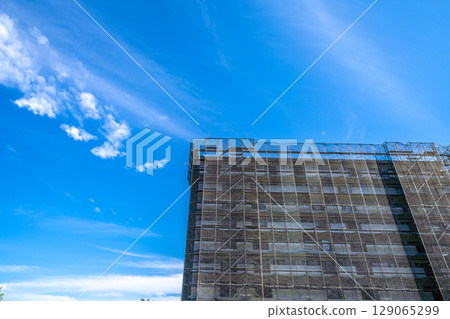 Yokohama cityscape, Japan, July 27th. Summer skies are spreading... View of scaffolding and protective netting for repairs and inspections of apartment buildings. Yokohama cityscape, Japan, July 27th. Summer skies are spreading... View of scaffolding and protective netting for repairs and inspections of apartment buildings. 129065299
