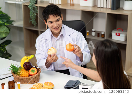 Nutrition Education. Doctor explaining healthy eating with fruits and pastries. 129065343