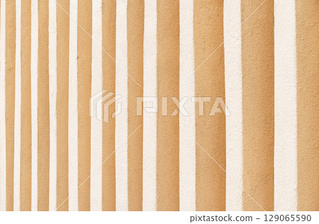 Creative texture of orange and white stripes on a rustic wall surface 129065590