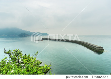 A magnificent view of the Seto Inland Sea from near Tomonoura and Yodohime Shrine, including a historic stone breakwater that curves beautifully into the sea. A magnificent view of the Seto Inland Sea from near Tomonoura and Yodohime Shrine, including a historic stone breakwater that curves beautifully into the sea. 129065843