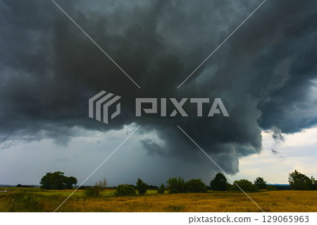 Dramatic storm clouds in the sky, dark severe storm clouds, supercell. 129065963