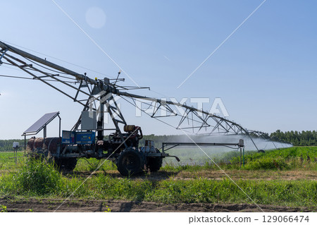 Autonomous machine is moving watering pivot along irrigation canal 129066474