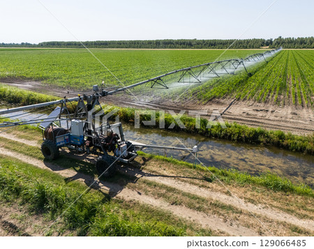 Autonomous machine is moving watering pivot along irrigation canal Autonomous machine is moving watering pivot along irrigation canal 129066485