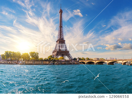 Eiffel Tower and the bridge over Seine river, famous view of Paris, France 129066558