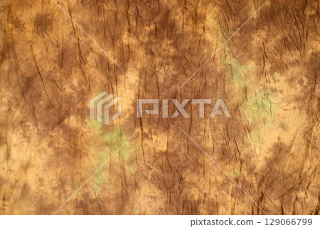 Brown wrinkled fabric texture with subtle green stains, abstract background for design, vintage or grunge style 129066799