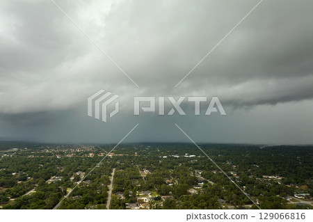Landscape of dark ominous clouds forming on stormy sky before heavy thunderstorm over rural town area Landscape of dark ominous clouds forming on stormy sky before heavy thunderstorm over rural town area 129066816