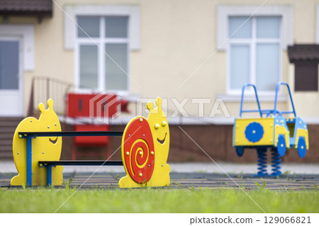 Kindergarten playground with bright toy car and funny bench. Children activities and recreation outdoors. Kindergarten playground with bright toy car and funny bench. Children activities and recreation outdoors. 129066821