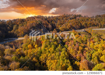 Highway road in North Carolina Appalachian mountains in fall season. Expressway lanes for fast passing of car traffic Highway road in North Carolina Appalachian mountains in fall season. Expressway lanes for fast passing of car traffic 129066871