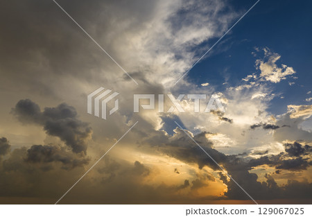 Dramatic sunset sky covered with colorful yellow clouds. Panoramic skyscape Dramatic sunset sky covered with colorful yellow clouds. Panoramic skyscape 129067025