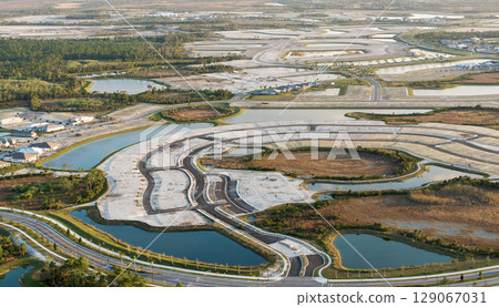 Development of real estate market in the USA. Aerial view of large construction site with building equipment on prepared soil in American rural area 129067031