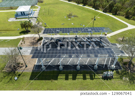 Destroyed by hurricane wind photovoltaic solar panels mounted on carport roof for producing green ecological electricity for electric vehicle charging. Consequences of natural disaster in Florida Destroyed by hurricane wind photovoltaic solar panels mounted on carport roof for producing green ecological electricity for electric vehicle charging. Consequences of natural disaster in Florida 129067041