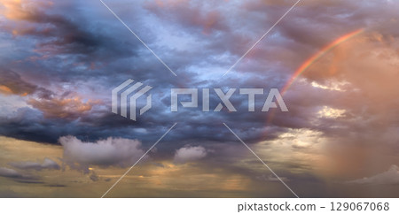 Colorful sunset sky with setting sun behind vivid orange and yellow clouds Colorful sunset sky with setting sun behind vivid orange and yellow clouds 129067068