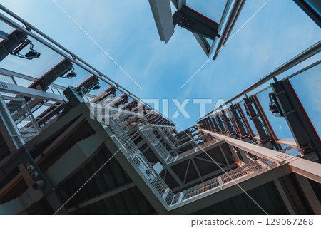 The Shard's steel and glass design is captured from below, emphasizing its height and angular structure against a clear blue sky in London. The Shard's steel and glass design is captured from below, emphasizing its height and angular structure against a clear blue sky in London. 129067268