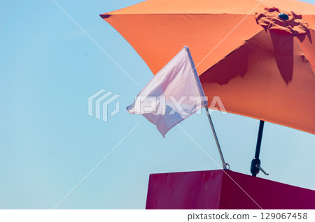White flag on the beach as information for tourists for swimming is allowed. White flag on the beach as information for tourists for swimming is allowed. 129067458