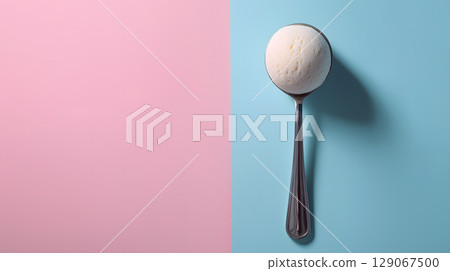 Scoop of creamy ice cream rests on shiny spoon, set against dreamy pastel pink and blue background, evoking sense of delight 129067500
