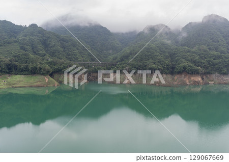 Morning mist drifts over the lake surface of Yamba Dam in Gunma Prefecture 129067669