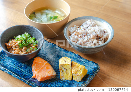 A home-style Japanese breakfast set featuring natto, grilled salmon, and miso soup A home-style Japanese breakfast set featuring natto, grilled salmon, and miso soup 129067734