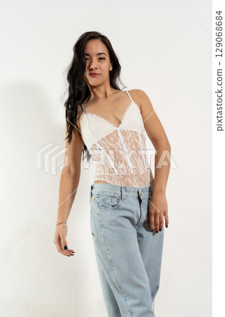 Young latin woman posing with white bodysuit and jeans on white background Young latin woman posing with white bodysuit and jeans on white background 129068684