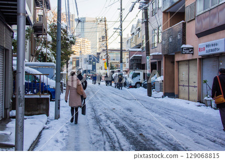 大雪過後,人們在城市中步行上下班或上學 大雪過後,人們在城市中步行上下班或上學 129068815