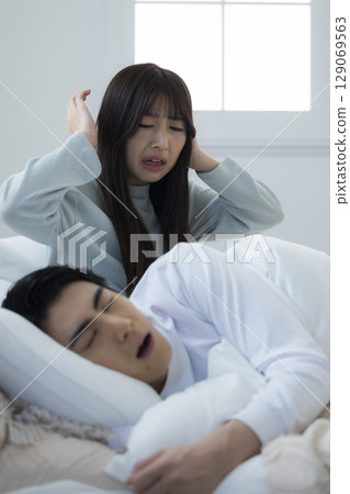 A young man sleeping and snoring in bed A young man sleeping and snoring in bed 129069563
