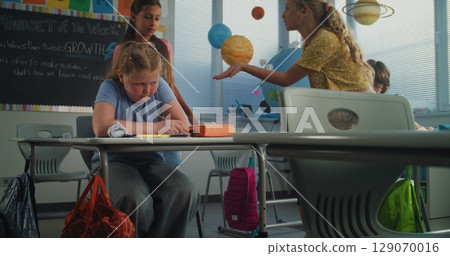 Sad School Girl Crying, Suffering from School Bullying, Peer Harassment from Classmates 129070016