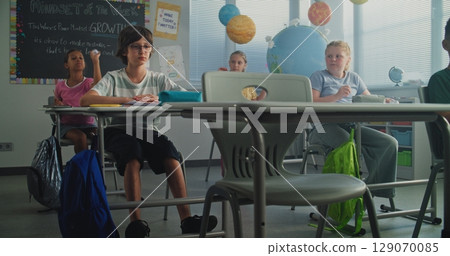 Depressed Primary School Boy Sitting at Desk While Classmates Abusing Him, Throwing Papers and Laughing 129070085