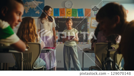 Female Teacher Presenting Elementary School Student. Smart Girl Giving Presentation on Ecology 129070148